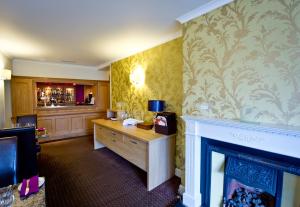 a hotel room with a fireplace and a bar at The Parklands Hotel in Perth