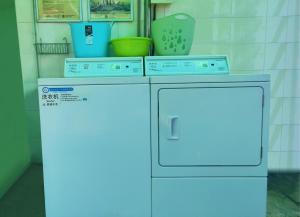 een wasmachine en een vaatwasser in de kamer bij Shenzhen Green Oasis Hotel, Baoan in Bao'an