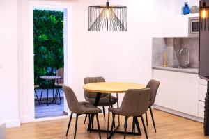 a kitchen with a table and chairs in a kitchen at Chinitas Urban Aparments in Málaga