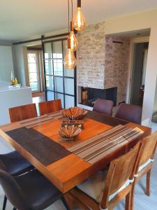 a dining room table with chairs and a fireplace at Villa de la Sablière in Amougies