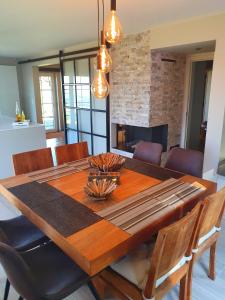 uma mesa de jantar com cadeiras e uma lareira em Villa de la Sablière em Amougies