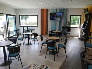 a dining room with tables and chairs and windows at Do Mi Si La Do Ré gîte partagé in Saint-Carreuc