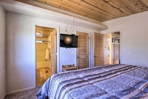 a bedroom with a bed and a flat screen tv at Rustic Bullhead City Retreat with Porch and Views in Bullhead City