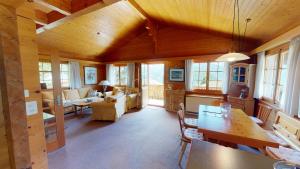 ein Wohnzimmer mit Holzdecken und ein Zimmer mit einem Tisch in der Unterkunft Casa Beata CB0 in Blatten bei Naters