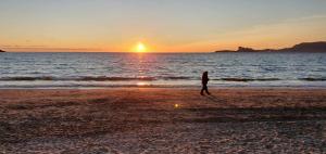 een persoon die bij zonsondergang op het strand loopt bij vacances à la plage in Saint-Cyr-sur-Mer