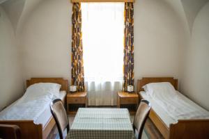 2 Einzelbetten in einem Zimmer mit Fenster in der Unterkunft Gästehaus Fogarasch in Făgăraş