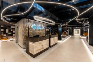 a lobby of a store with a reception counter and lights at Hotel Vision in Budapest