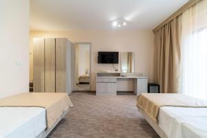 a hotel room with two beds and a desk at Hotel RIO VERDE in Podgorica