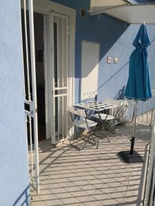 努馬納的住宿－Grazioso appartamento in Centro a Numana，一个带桌椅和蓝色墙壁的庭院