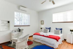 a bedroom with a bed and two chairs at Albourne Guesthouse in Somerset West