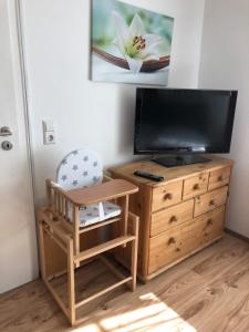 a living room with a television and a wooden dresser at Guest Appartements mit 2 getrennten Schlafzimmern für 4 Personen 24h check in in Aalen