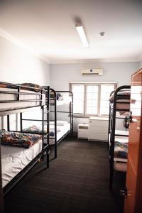 a dorm room with three bunk beds in it at The Emperors Crown Hostel in Perth