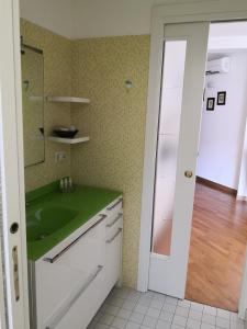 努馬納的住宿－Grazioso appartamento in Centro a Numana，厨房配有绿色水槽和镜子
