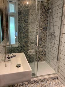a bathroom with a shower with a sink and a shower at St Athans Hotel in London
