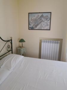 努馬納的住宿－Grazioso appartamento in Centro a Numana，卧室配有白色的床和散热器