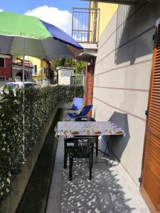a table and chairs on a patio with an umbrella at Residenza Silvana Apt Cielo and Apt Giardino on the ground floor with parking in Verbania