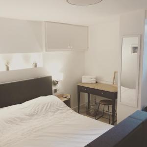 a bedroom with a bed and a desk with a desk at One One Five Apartment in Swansea