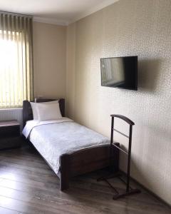 a bedroom with a bed with a television on the wall at Gray Hotel in Vynohradiv +26 photos