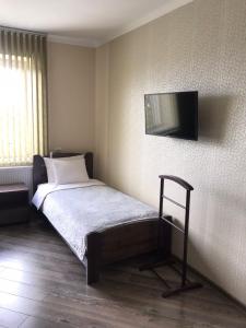 a bedroom with a bed with a television on the wall at Gray Hotel in Vynohradiv