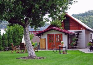 a small house with a tree in the yard at u Jaňola in Oščadnica