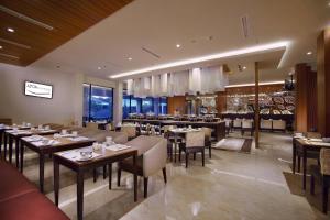 a restaurant with tables and chairs and a bar at ASTON Bojonegoro City Hotel in Bojonegoro