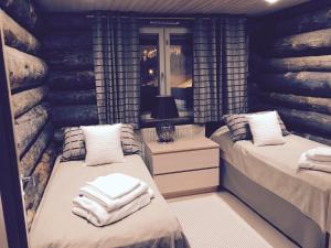 a bedroom with two beds with towels on them at Villa Valtavaara in Ruka