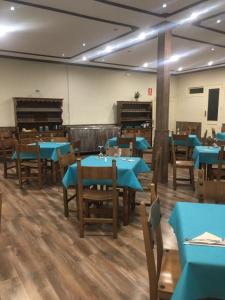 a dining room with blue tables and benches at EL CANDIL in Villacastín