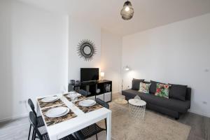 a living room with a table and a couch at Le Mille - Cosy appartement 4 personnes - 15mn du centre de Lyon in Villeurbanne