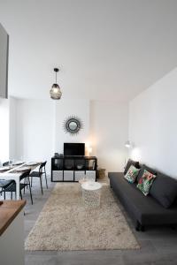 a living room with a couch and a table at Le Mille - Cosy appartement 4 personnes - 15mn du centre de Lyon in Villeurbanne