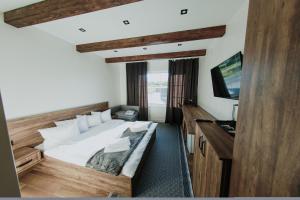 una camera con un grande letto e una televisione di Saliuk Lodge a Solochyn