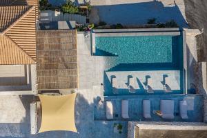 an overhead view of a swimming pool with chairs next to it at GAGOUINOS COTTAGE in Koríthion