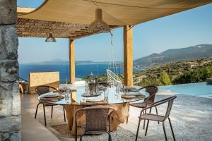 einen Esstisch mit Stühlen und Meerblick in der Unterkunft GAGOUINOS COTTAGE in Koríthion