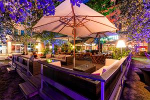 a restaurant with tables and umbrellas at night at Pentahotel Leipzig in Leipzig