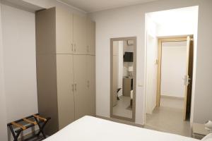 a bedroom with a white bed and a mirror at B&B Contessa in Gubbio