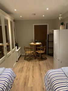 a kitchen with a table and chairs and a refrigerator at Studio in Stanmore