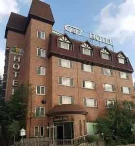 un grand bâtiment en briques avec un panneau d'hôtel dans l'établissement Green and Blue Hotel, à Pyeongchang