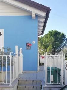 努馬納的住宿－Grazioso appartamento in Centro a Numana，蓝色的房子,设有大门和椅子