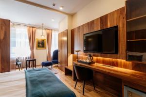 ein Hotelzimmer mit einem Bett und einem Flachbild-TV in der Unterkunft Boutique Hotel Dobrna - Terme Dobrna in Dobrna