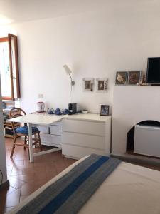 a white room with a desk and a table with a lamp at STANZA INDIPENDENTE SUPER ARREDATA CENTRALE E LUMINOSISSIMA in Rio nellʼElba