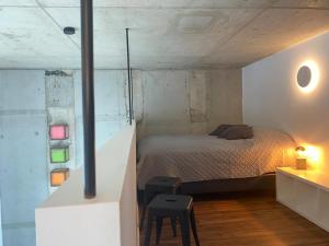 1 dormitorio con cama, mesa y taburete en Soulfactory Apartments, en Neu-Ulm