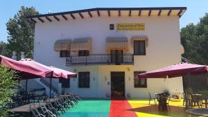 a building with a rainbow floor and chairs and umbrellas at Hotel-Locanda ZANZARINA D'ORO nel PARCO OGLIO SUD in Calvatone