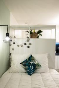 a white bed with a pillow on top of it at La Suite Saint Georges - Beau studio cosy et design à 5 mn métro Vieux Lyon in Lyon