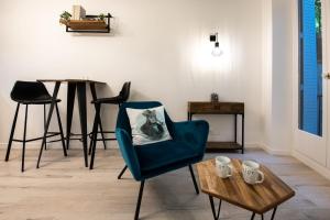 a living room with a blue chair and a table at La Suite Saint Georges - Beau studio cosy et design à 5 mn métro Vieux Lyon in Lyon