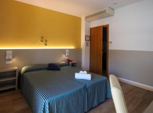 una camera con un letto e una parete gialla di Hotel Stockholm a Lido di Jesolo
