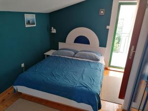 een slaapkamer met een bed met een blauwe muur bij Apartman Mia Biograd in Biograd na Moru