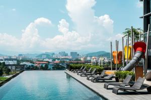 a pool on the top of a building with lounge chairs at ExpressionZ KLCC By Starwood Luxury in Kuala Lumpur