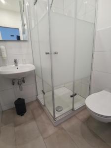 a bathroom with a shower and a toilet and a sink at MAX Hotel Düsseldorf in Düsseldorf