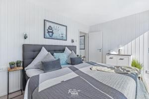 a bedroom with a large bed with blue pillows at Bora in Olpenitz