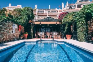 a swimming pool in the courtyard of a mansion at Hotel Carabeo in Nerja