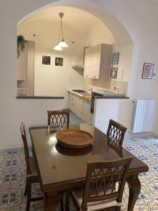 Le Esperidi House في رافيلو: مطبخ مع طاولة وكرسيين ومطبخ مع ممر